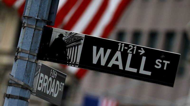 Pantallas rojas en Wall Street mostrando caídas del Dow Jones y S&P 500 por tensiones con Fed e Irán