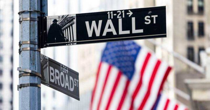 Kevin Warsh en rueda de prensa como nuevo presidente de la Fed con gráficos de inflación al 3.5% y caídas en Wall Street de fondo