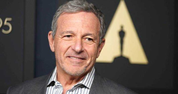 Bob Iger en reunión de Disney con gráficos de bolsa y logo de la empresa, reflejo de su legado y transición