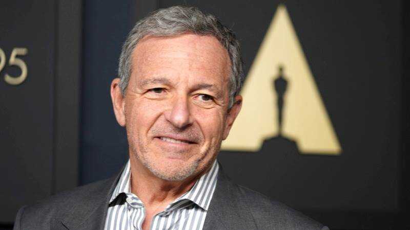 Bob Iger en reunión de Disney con gráficos de bolsa y logo de la empresa, reflejo de su legado y transición