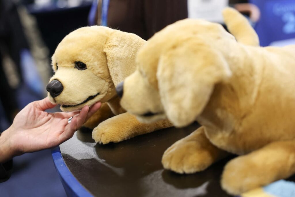 Robot mascota Jennie interactuando con anciano en el CES 2026, mostrando su diseño realista y sensores de monitoreo