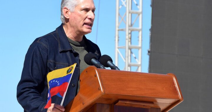 Miguel Díaz-Canel en discurso con bandera de Cuba al fondo, respondiendo a sanciones de Trump con gesto firme
