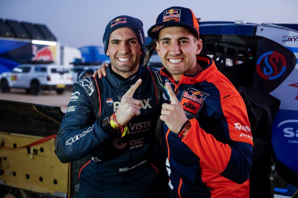 Hermanos Benavides abrazándose en el desierto tras ganar etapas en el Dakar 2026 con banderas argentinas