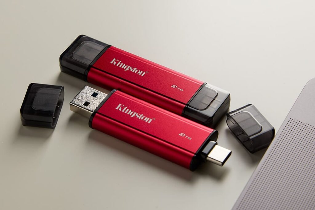 Kingston Dual Portable SSD en mano mostrando conectores USB-A y USB-C con fondo de transferencia de datos a 1050MB/s