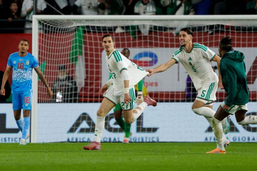 Adil Boulbina celebra su gol al ángulo en el minuto 118 que clasificó a Argelia con Riyad Mahrez abrazándolo en el fondo