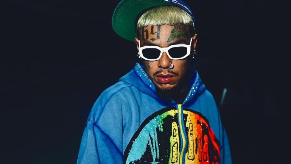 Tekashi 6ix9ine con tatuajes visibles en patio carcelario mientras guardias observan a Maduro a lo lejos