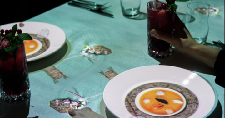 Proyección 3D del chef animado de 6 cm cocinando sobre una mesa en Quito con platos reales sincronizados