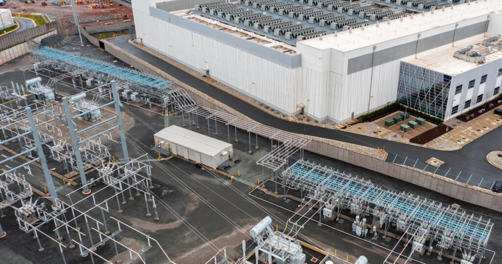 Donald Trump en reunión con gobernadores firmando acuerdo energético mientras gráficos muestran subida de precios de electricidad por demanda de IA