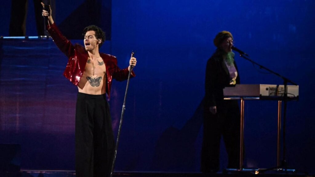 Harry Styles en escenario con luces neón durante anuncio de gira 'Together, Together 2026' con fechas en Latinoamérica