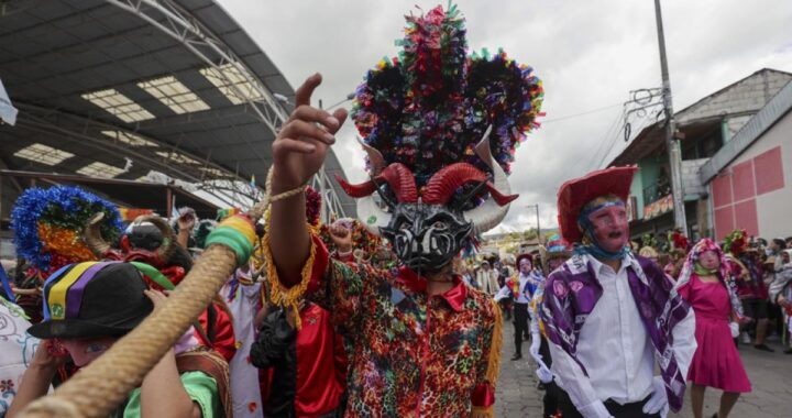 Diablos con máscaras artesanales de 11 kg bailando en la Diablada de Píllaro, Ecuador