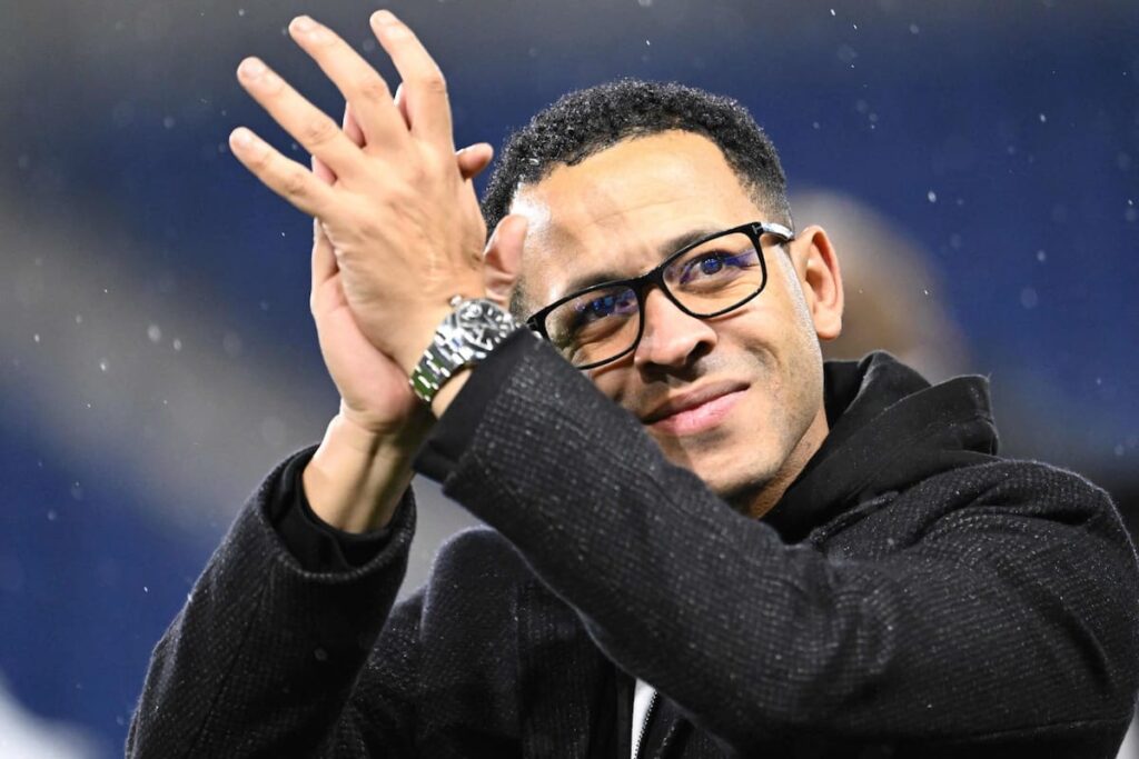 Liam Rosenior en rueda de prensa con camiseta del Chelsea y gesto serio tras su fichaje como técnico urgente