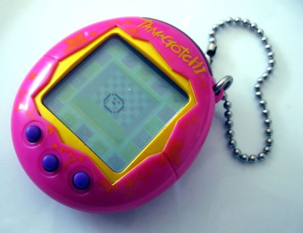 Tamagotchi vintage de 1996 junto a modelo 2024 en pantalla color, mostrando su evolución en 30 años