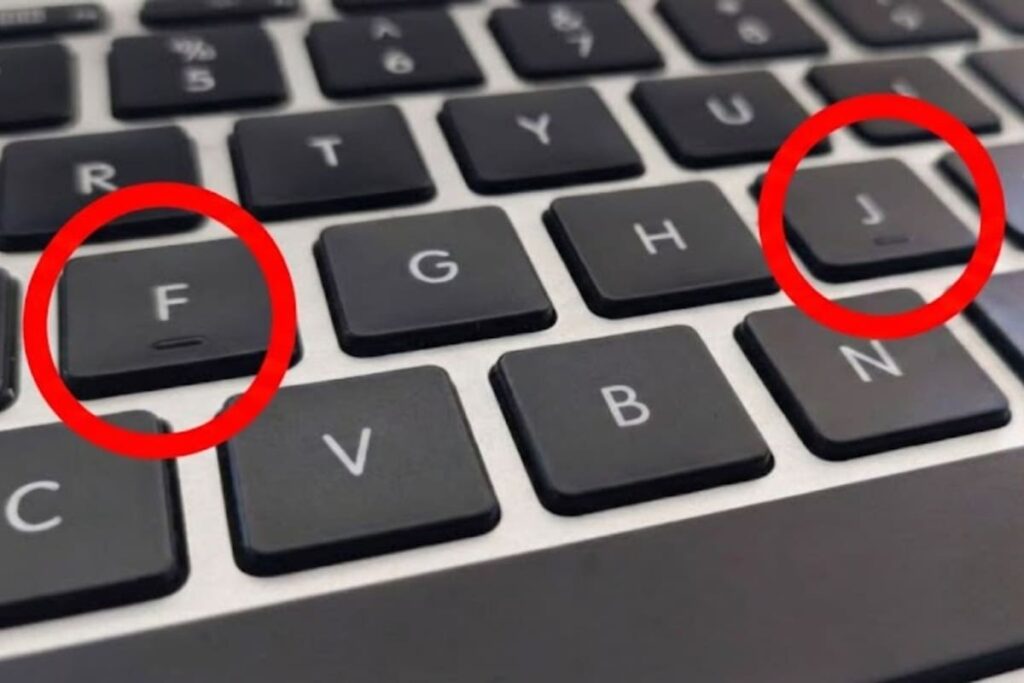 Primer plano de teclado con rayas táctiles en F y J destacadas en relieve, clave para escribir sin mirar