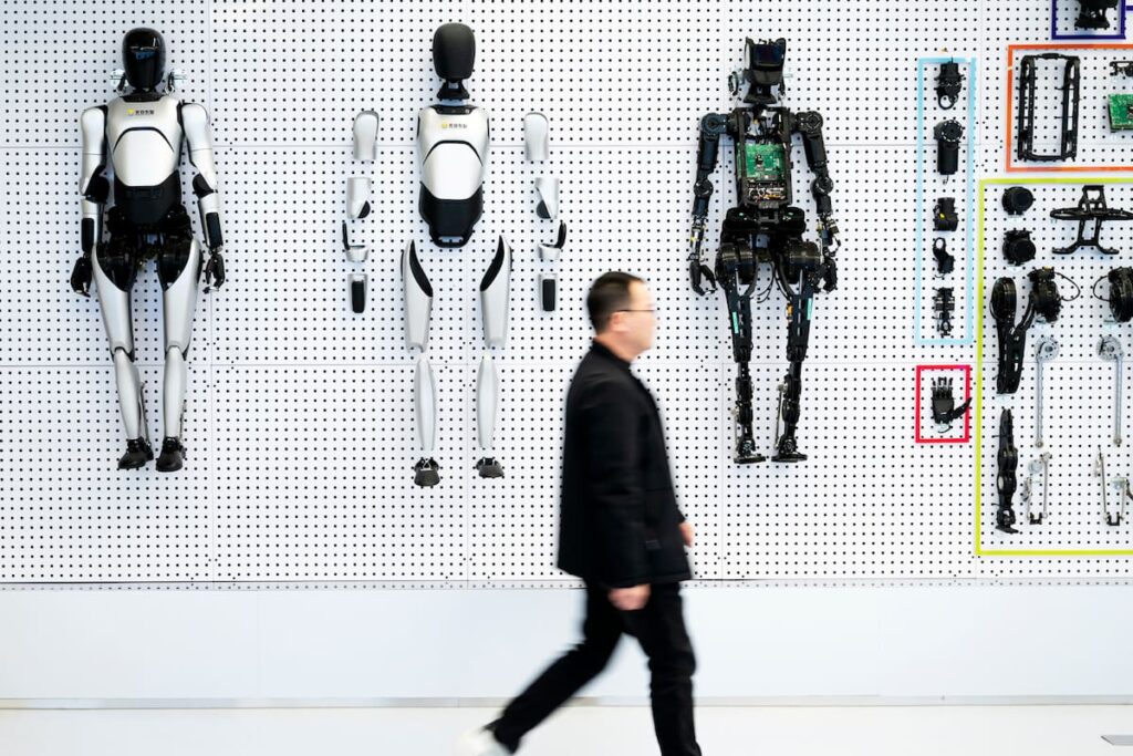Prototipo de robot humanoide Optimus de Tesla en laboratorio con pantallas de IA generativa al fondo
