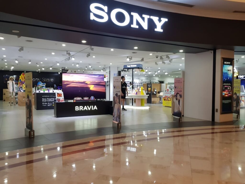 Ejecutivos de Sony y TCL firman acuerdo con televisor Bravia Mini LED de fondo, simbolizando alianza estratégica