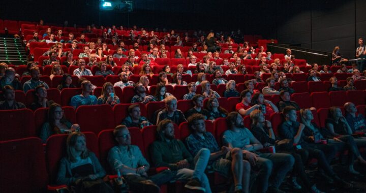 Pantalla de cine mostrando un trailer con escenas clave marcadas en rojo como 'spoiler' por demanda legal