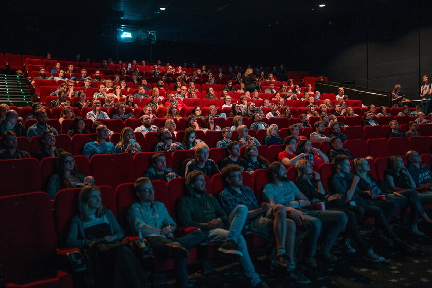 Pantalla de cine mostrando un trailer con escenas clave marcadas en rojo como 'spoiler' por demanda legal