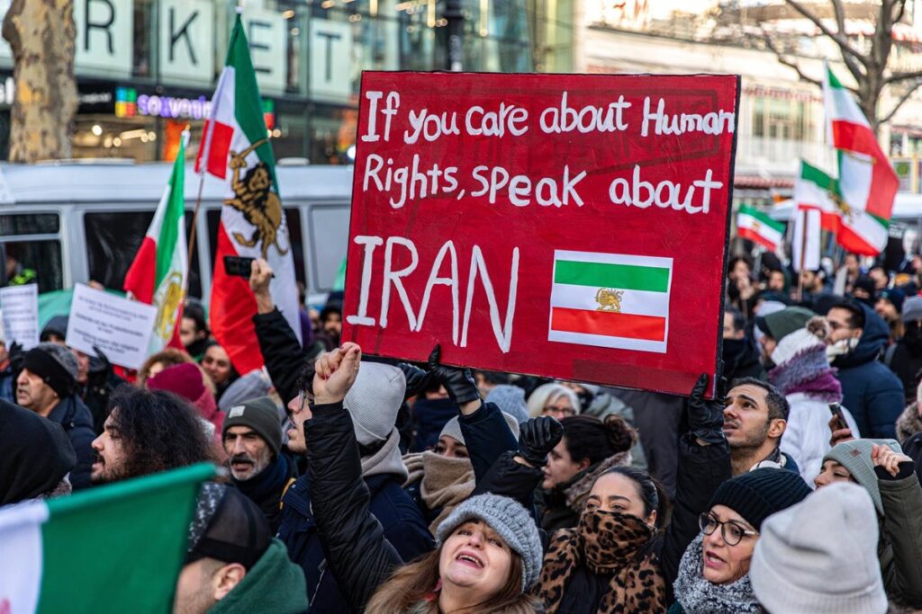 Manifestantes iraníes enfrentando fuerzas militares con armas de guerra durante protestas de 2022