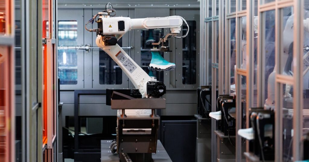 Brazos robóticos en fábrica coreana aplicando filamentos para crear zapatillas premium sin costuras en 3 minutos