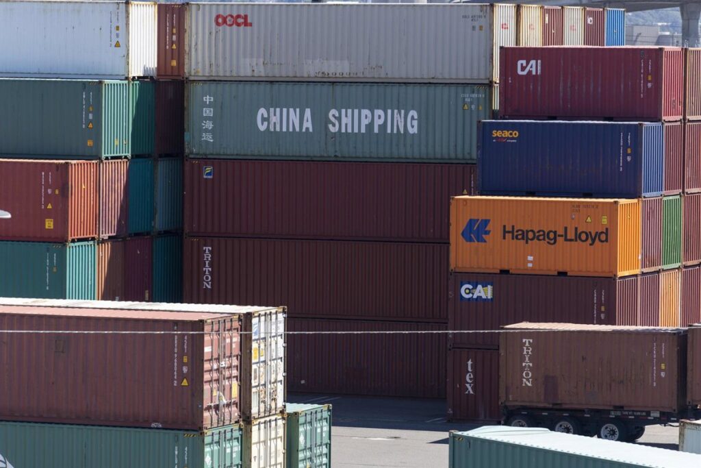 Bandera de China sobre gráficos de exportaciones con símbolo de dólar roto por aranceles del 15%