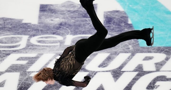 Ilia Malinin en pleno backflip sobre hielo durante rutina olímpica 2026 con público en vilo