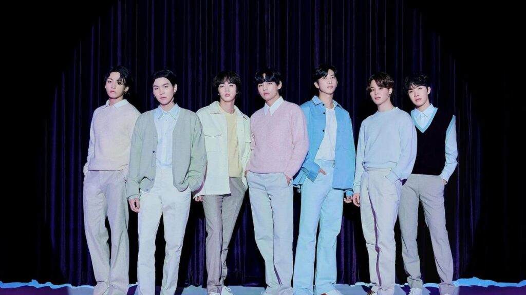 BTS en escenario masivo de Gwanghwamun con proyecciones de su concierto en Netflix y el logo de ARIRANG