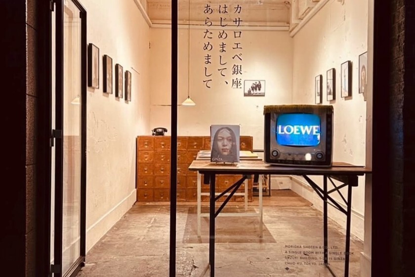 Interior minimalista de librería en Tokio con un único libro exhibido en pared blanca y suelo de madera