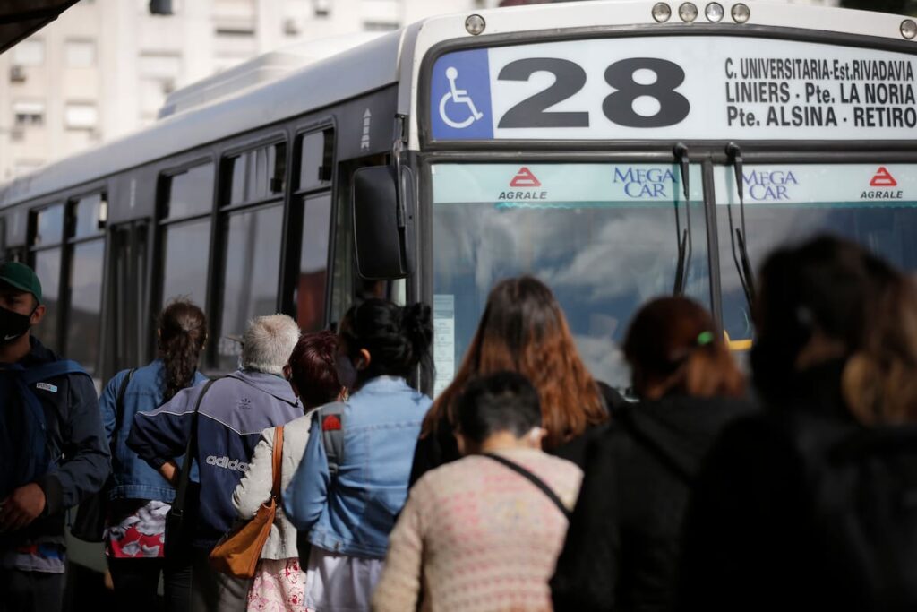 Pantalla de celular mostrando la app de colectivos con mapa en tiempo real y buses acercándose a paradas en Buenos Aires