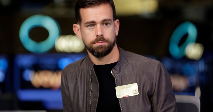 Jack Dorsey en conferencia anunciando despidos masivos por IA con gráficos de acciones en alza al 27%