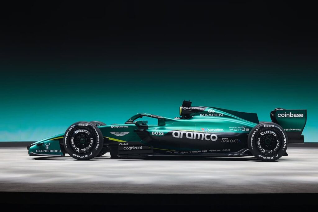 Adrian Newey y Fernando Alonso analizando el AMR26 en boxes, con el monoplaza mostrando detalles técnicos del reglamento 2026