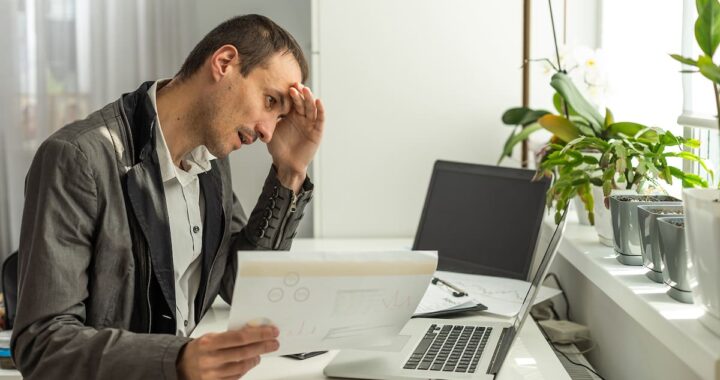 Empleado agotado frente a pantalla con gráficos de IA y datos de productividad en aumento