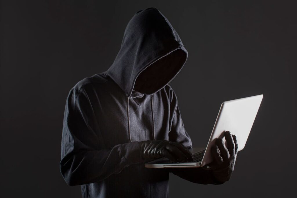 Pantalla de computadora con alerta roja de 'Acceso no autorizado detectado' y código malicioso en segundo plano