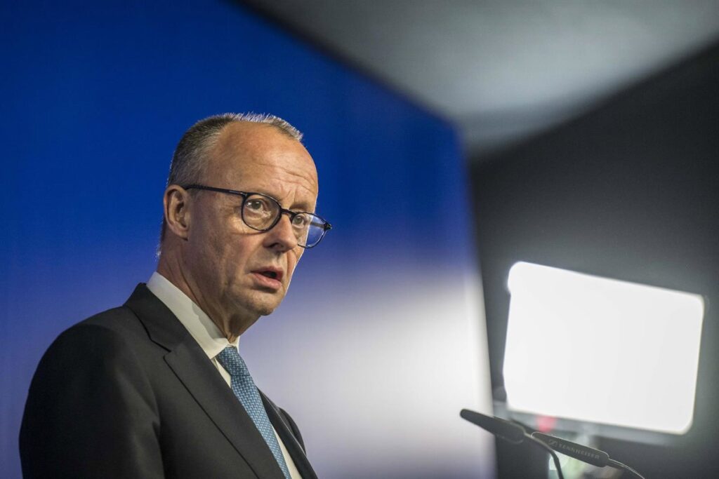Friedrich Merz en la Conferencia de Múnich advirtiendo sobre la crisis geopolítica de Europa en 2024 con mapa de tensiones globales