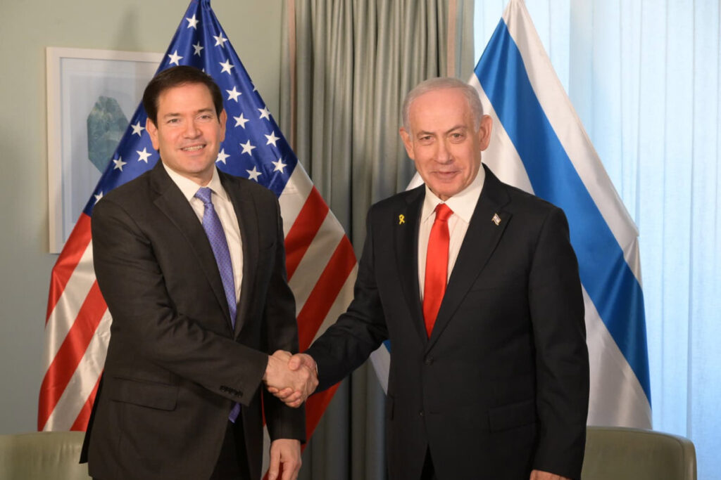 Benjamin Netanyahu y Donald Trump firman documento de la Junta de Paz con mapa de Gaza de fondo y banderas de Israel y EE.UU.