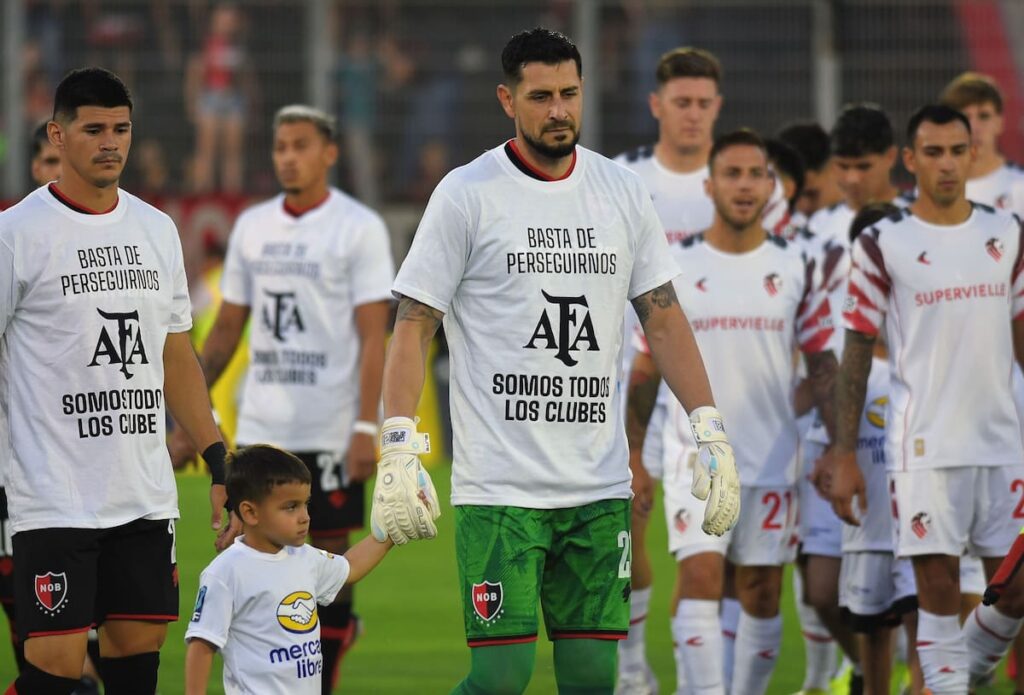 Jugadores de Newell’s con camiseta blanca de protesta 'Basta de perseguirnos' en partido vs Estudiantes