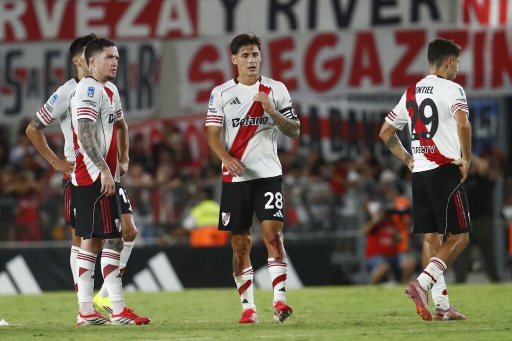 Jugadores de River abatidos tras recibir el 4-1 de Tigre en el Monumental, con hinchas abandonando el estadio