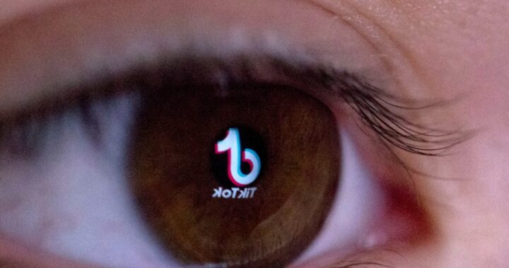 Pantalla de móvil mostrando el logo de TikTok con un fondo de alerta roja y el símbolo de la UE superpuesto