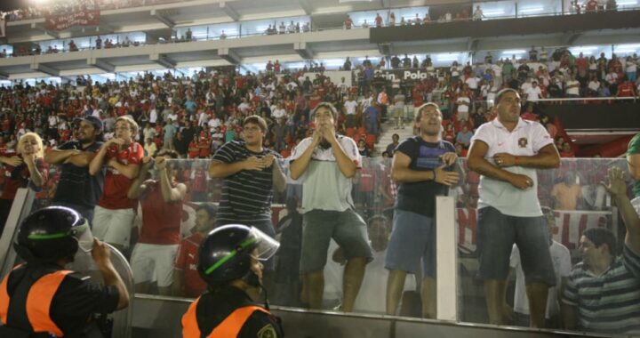 Hincha con el rostro tenso gritando 'movete y dejá de joder' desde la tribuna en un estadio argentino lleno de tensión