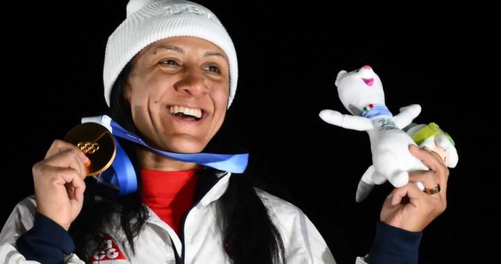 Elana Meyers Taylor con medalla de oro en bobsleigh, abrazando a sus hijos sordos en el podio olímpico
