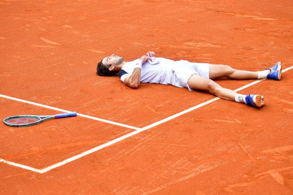 Tomás Etcheverry agotado tras 22 horas de partido en la arcilla de Río, con el puño en alto celebrando el pase a la final