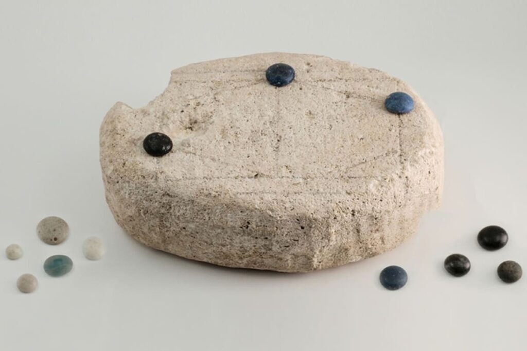 Tablero de piedra del Ludus Coriovalli con marcas erosionadas analizadas por IA para reconstruir sus reglas