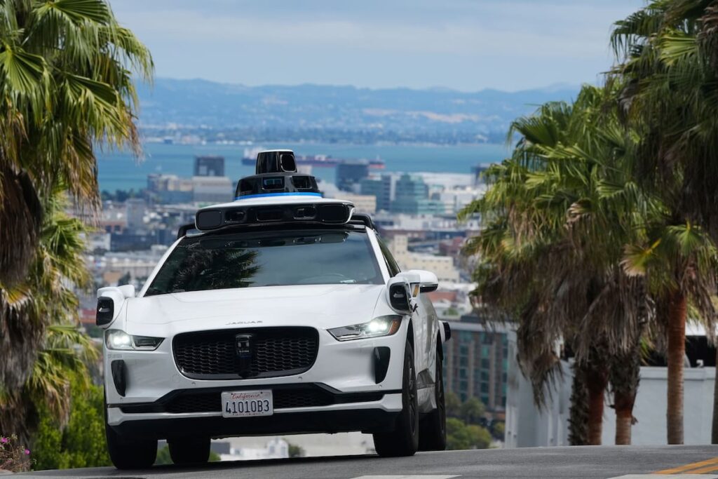 Pantalla de control remoto de Waymo con operador en Filipinas monitoreando un robotaxi en calles de EE.UU.