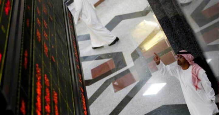 Pantallas rojas en la bolsa de Dubái mostrando 'Mercado cerrado' con gráficos de caída de petróleo y dirham en segundo plano