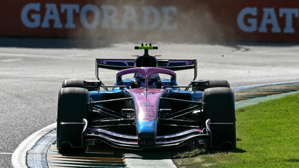 Oscar Piastri en su McLaren liderando la FP2 en Melbourne con el fondo plano de su RB20 visible y Aston Martin en boxes con mecánicos revisando baterías dañadas