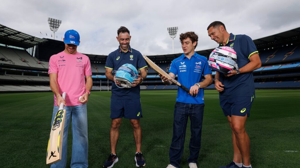 Franco Colapinto con el casco argentino y el Alpine A526 en el Melbourne Cricket Ground junto a Glenn Maxwell