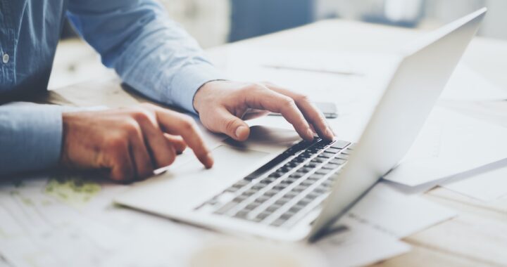 Manos recortando un documento PDF en pantalla con herramientas digitales destacando área seleccionada