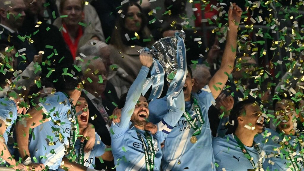 Nico O’Reilly celebra su segundo gol de cabeza en la final de la Carabao Cup 2024, con Pep Guardiola de fondo en Wembley