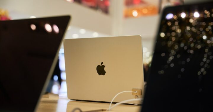 MacBook Pro y Air con chips M5 sobre mesa de trabajo mostrando pantalla con gráficos de rendimiento en IA
