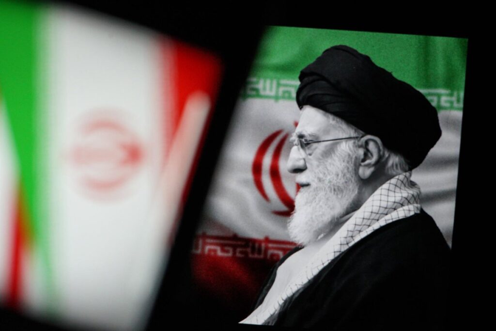 Bandera iraní a media asta con misiles de fondo tras muerte de Jamenei en ataque conjunto Israel-EE.UU.