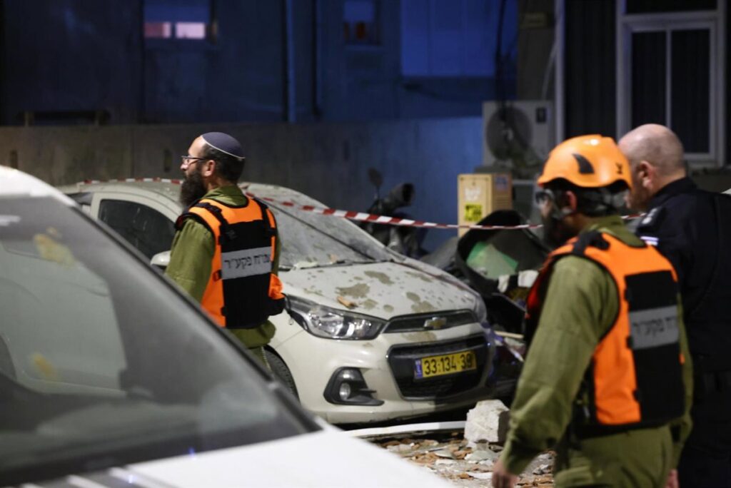 Explosión nocturna en Tel Aviv tras misiles iraníes en represalia por muerte de Alí Lariyani, con humo iluminado por luces de emergencia
